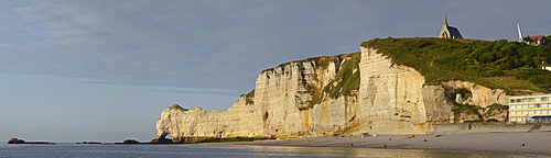 The chalk cliffs of Ã¢Ë†Å¡ÃƒÂ¢tretat with the natural arch Falaise dÃ‚Â¬ÃƒÂ­Amont or Porte d'Amont and the chapel Notre-Dame-de-la-Garde illuminated by warm evening light, CÃ¢Ë†Å¡Ã‚Â¥te d'AlbÃ¢Ë†Å¡Ã‚Â¢tre, DÃ¢Ë†Å¡Ã‚Â©partement Seine-Maritime, Haute-Normandie, France, Europe