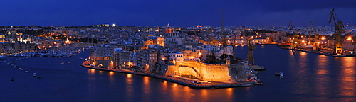 The floodlit Fort St. Angelo on the tip of the peninsula Vittoriosa, Birgu, as seen from Valletta across the Grand Harbor at the blue hour after sunset, Malta, Europe