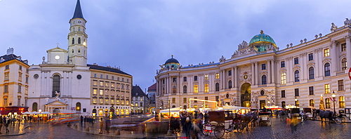 Christmas Market stalls and St. Michael Catholic Church in Michaelerplatz, Vienna, Austria, Europe