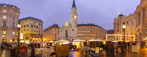 Christmas Market stalls and St. Michael Catholic Church in Michaelerplatz, Vienna, Austria, Europe