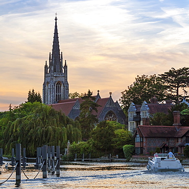 Man and woman on boat with All Saints Church in the background, Marlow, Buckinghamshire, England, United Kingdom, Europe