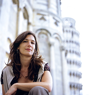 Portrait of a young woman in front of Cathedral and Leaning Tower of Pisa, Italy