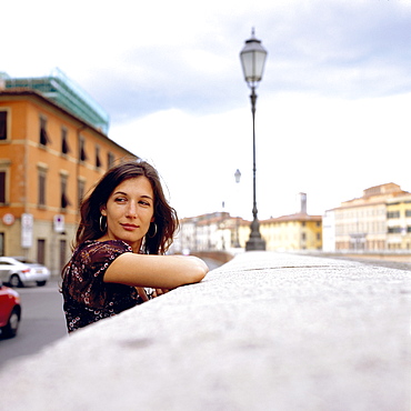 Young woman leaning against wall, Pisa, Italy
