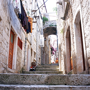 View inside an alley wiht old stone houses and clotheslines at facade, Korcula, Dalmatia, Croatia