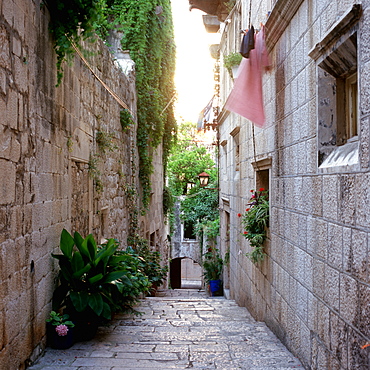 View inside an alley wiht old stone houses and clotheslines at facade, Korcula, Dalmatia, Croatia