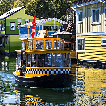 A small tour boat in Fisherman's Wharf in the Inner Harbour of Victoria, Vancouver Island, Victoria, British Columbia, Canada