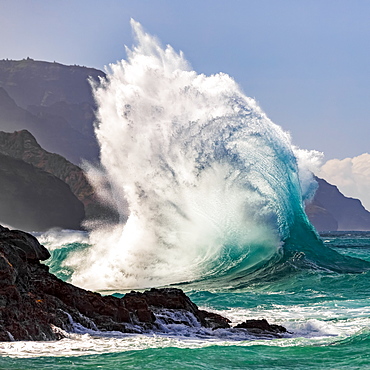 Large ocean wave crashes into rock along the Na Pali Coast, Kauai, Hawaii, United States of America