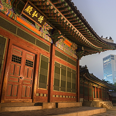 Deoksugung Palace, traditional Korean building, illuminated at dusk, with modern building in distance, Seoul, South Korea, Asia