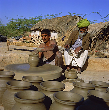 Potter with his father at potter's wheel, Rajasthan, India, Asia