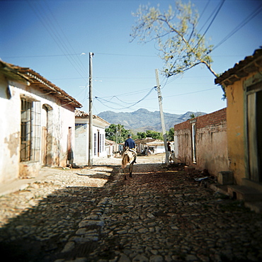 Street scene with man on horseback, Trinidad, Cuba, West Indies, Central America