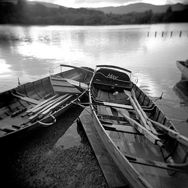 Image taken with a Holga medium format 120 film toy camera of two old boats by lake side, Derwentwater, Lake District National Park, Cumbria, England, United Kingdom, Europe