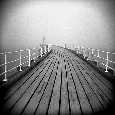 Image taken with a Holga medium format 120 film toy camera looking along timber boardwalk of Whitby pier on misty winter's day, Whitby, North Yorkshire, England, United Kingdom, Europe