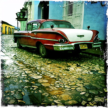 Old American car parked on a cobbled street in the town of Trinidad, Cuba, West Indies, Central America