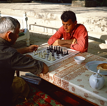 Uzbek men playing chess in a tea house garden, Bukhara, Uzbekistan, Central Asia, Asia