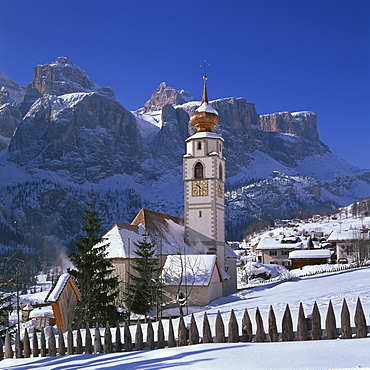 The church and village of Colfosco in Badia and Sella Mountains under snow in winter in the Dolomites, South Tirol, Trentino Alto Adige, Italy, Europe