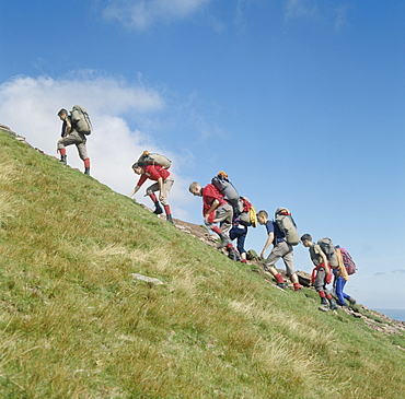 Backpackers scrambling, Pen y Fan, Brecon Beacons, Powys, Wales, United Kingdom, Europe