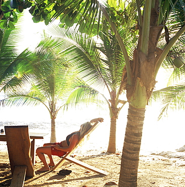 Young woman relaxes on Avellans Beach, Costa Rica, Central America
