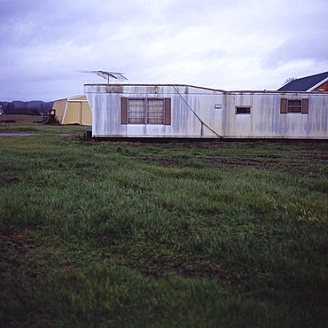 Trailer home with antenna on grassy lawn, Vashon Island, Washington State, United States of America, North America