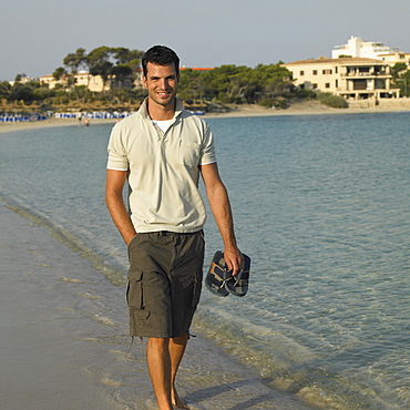 Man walking along seashore