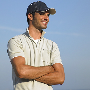 Man on beach wearing baseball cap