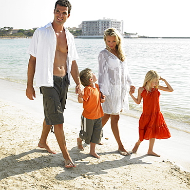 Parents and children (6-8) walking on beach