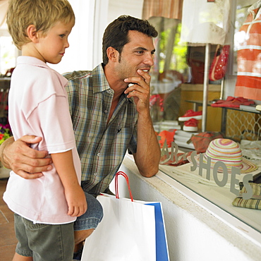 father and son (6-8) window shopping