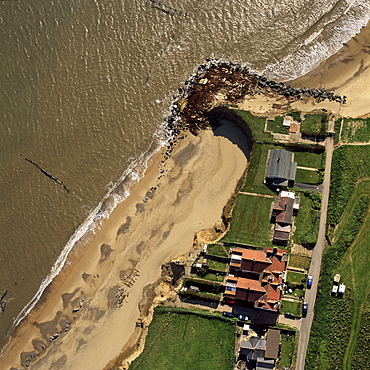 Aerial view of Happisburgh, showing precarious position of several houses as cliffs are eroded by coastal erosion, Norfolk, England, United Kingdom, Europe