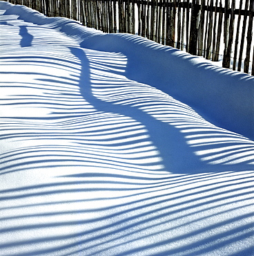 Lattice fence's shadows in snow