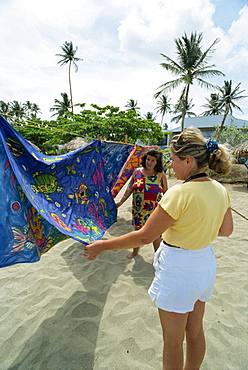 Tourist choosing tablecloth, Turtle Beach, Tobago, West Indies, Caribbean, Central America