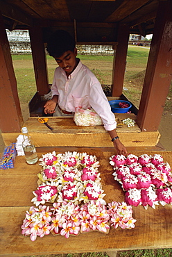 Young man selling offerings at the Temple of the Tooth, Kandy, Sri Lanka, Asia