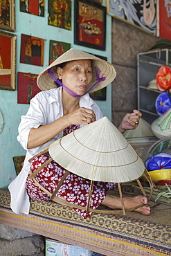 A women weaves a conical hat at a crafts village, Hue, Vietnam, Indochina, Southeast Asia, Asia