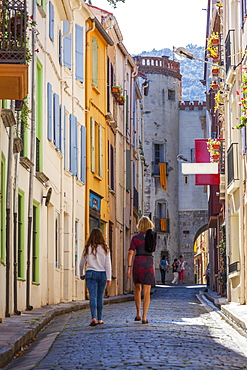 Two women walking towards the old town, Ceret, Vallespir region, Pyrenees, France, Europe