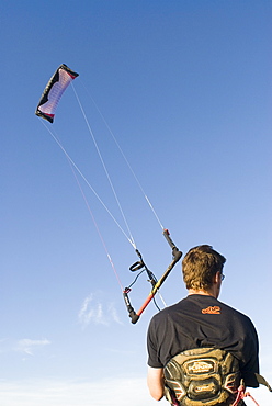 Man holding power kite on Weston-Super-Mare beach, UK