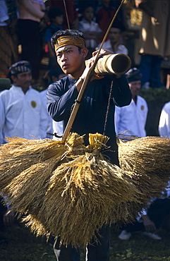 Kasepuhan musician carrying rice bundles at annual rice festival Seren Tahun, West Java, Indonesia