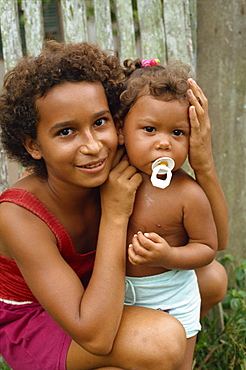 Portrait of a girl and child with a dummy at Pacoval Village on Curua Una river in the Amazon area of Brazil, South America