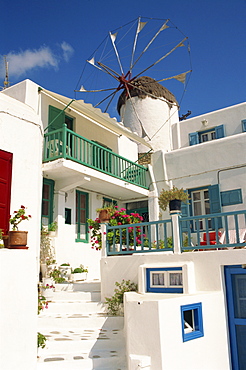 White house with windmill in the background on Mykonos, Cyclades Islands, Greek Islands, Greece, Europe