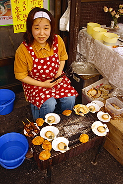 Portrait of a woman selling shellfish delicacies on a street stall in Hakodate, Japan, Asia