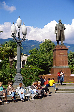 People sitting on benches near a statue of Lenin in Yalta, the Crimea, Ukraine, Europe