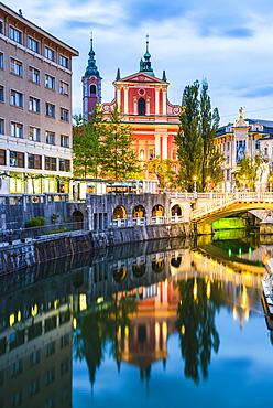 Ljubljana triple bridge (Tromostovje) and Franciscan Church of the Annunciation reflected in Ljubljanica River at night, Ljubljana, Slovenia, Europe