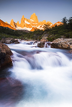 Sunrise Mount Fitz Roy (Cerro Chalten) and waterfall seen on Lago de los Tres hike, UNESCO World Heritage Site, El Chalten, Patagonia, Argentina, South America