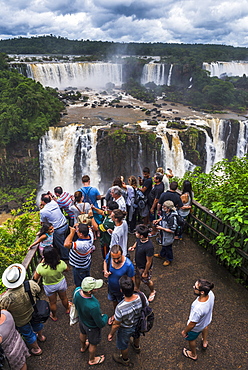 Tourists at Iguazu Falls (Cataratas del Iguacu), UNESCO World Heritage Site, on Brazilian side viewing platform, border of Brazil Argentina and Paraguay, South America