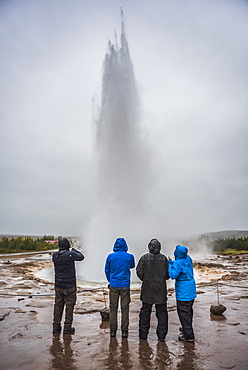 Tourists watching Strokkur Geyser erupt, Geysir, The Golden Circle, Iceland, Polar Regions