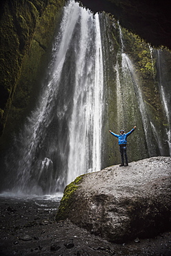 Tourist at the hidden Gljufrabui Waterfall, near Seljalandsfoss, South Iceland (Sudurland), Iceland, Polar Regions