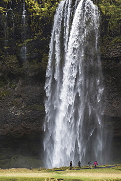 Tourists at Seljalandsfoss, a famous waterfall just off route 1 in South Iceland (Sudurland), Iceland, Polar Regions