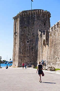 Tourist walking towards Kamerlengo Fortress (Gradina Kamerlengo), Trogir, UNESCO World Heritage Site, Dalmatian Coast, Croatia, Europe 