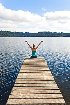 Woman sitting on a jetty, Lake Ianthe, West Coast, South Island, New Zealand, Pacific 