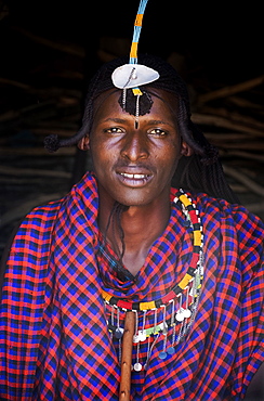 Portrait of a single Masai Mara man wearing traditional jewelry, headpiece and clothes, Masai Mara National Reserve, Kenya, East Africa, Africa