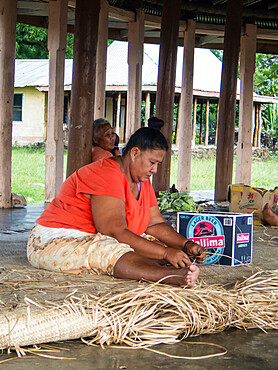 Woman with children weaving traditional mats in the town of Lufilufi on the island of Upolu, Samoa, South Pacific Islands, Pacific