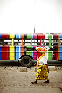 Merchant passing a school bus, Cotonou, Littoral Department, Benin