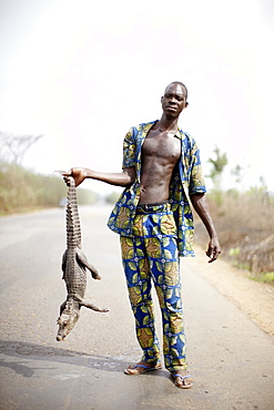 Man selling crocodile at national road, Abomey, Zou Department, Benin